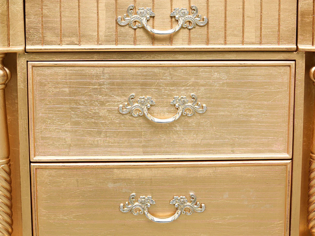 Close-up of metallic drawer handles on luxury French antique nightstand