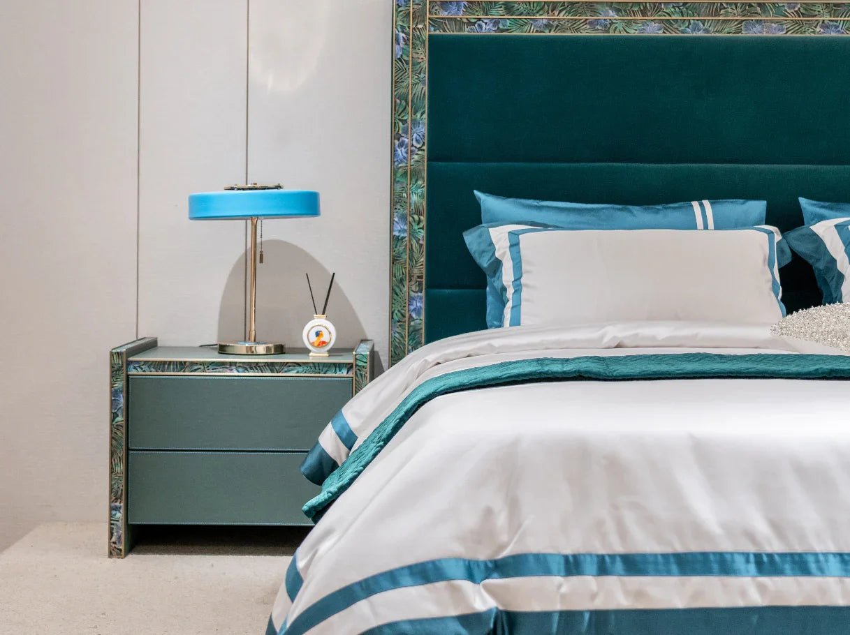 Art Deco nightstand with brass accents next to modern bed in teal upholstery