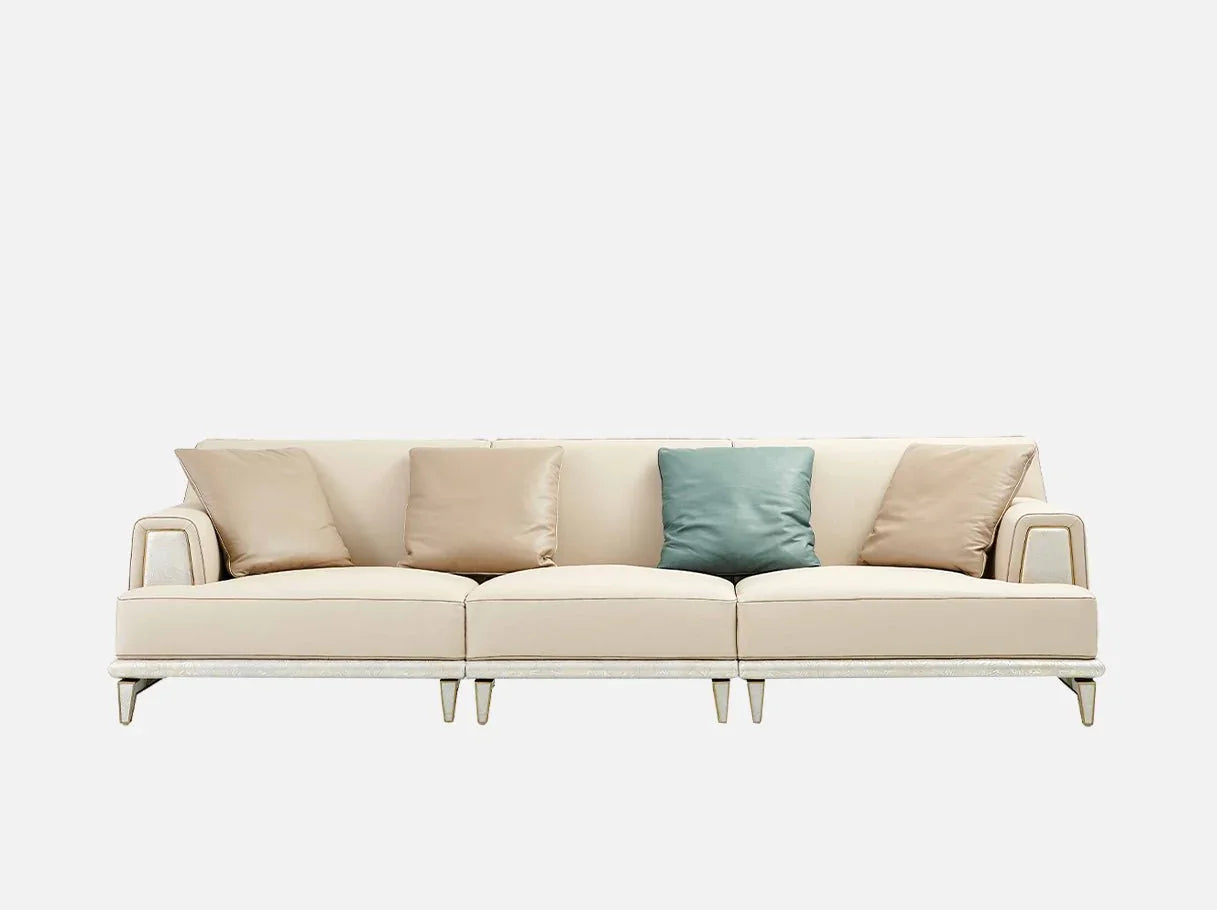Front view of modern sofa in old money aesthetic, with curved backrest, plush tailored cushions, brass-plated stainless steel base, and leather upholstery.