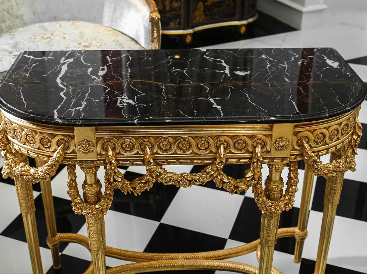 Close-up of polished black marble tabletop on retro console table CS-0238 with detailed gold leaf frame and floral carvings.