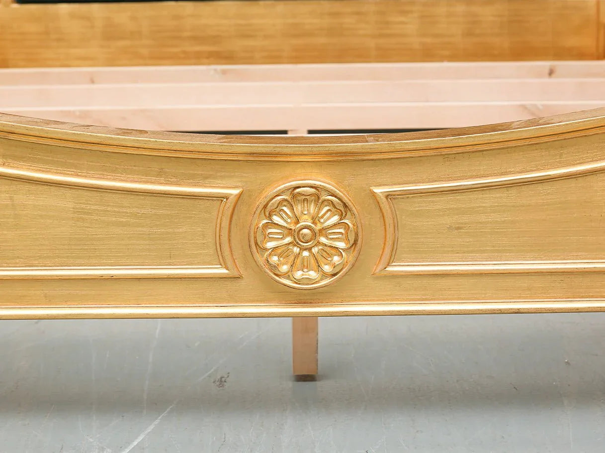 Footboard detail of French bed B-048 featuring carved beechwood panel with gold leaf accents.