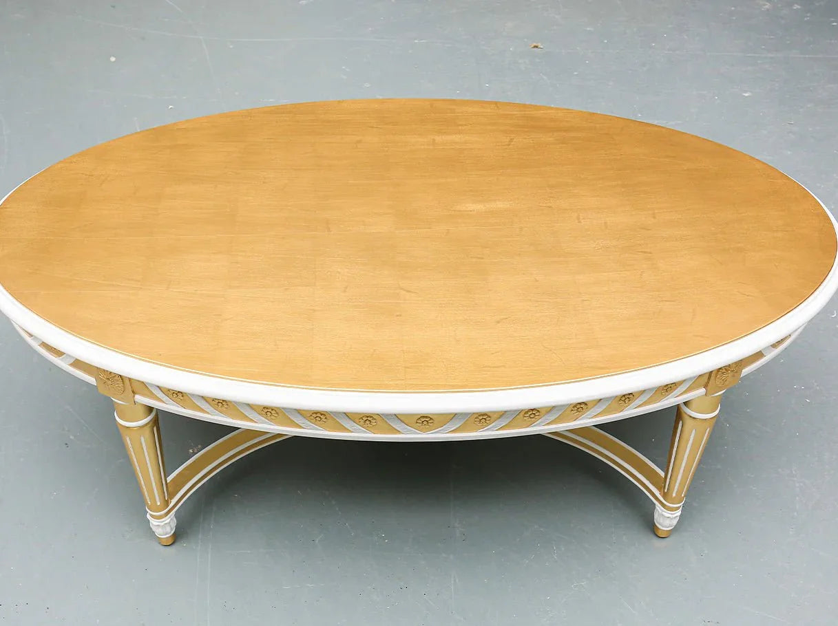 Top view of oval coffee table CT-0087 highlights the spacious wooden surface framed with classical carvings and gold leaf accents.