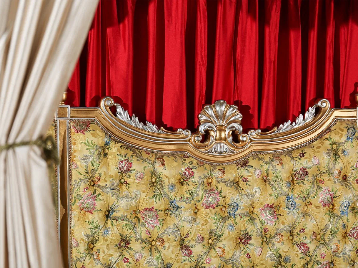 Close-up of B-400 canopy bed headboard with patterned jacquard fabric, hand-carved beechwood, and gold leaf accents.
