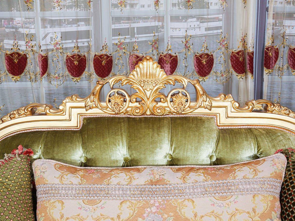 Close-up of French sofa S-1146 crest with ornate hand-carved scrollwork, gold leaf finish, and plush green velvet backrest.