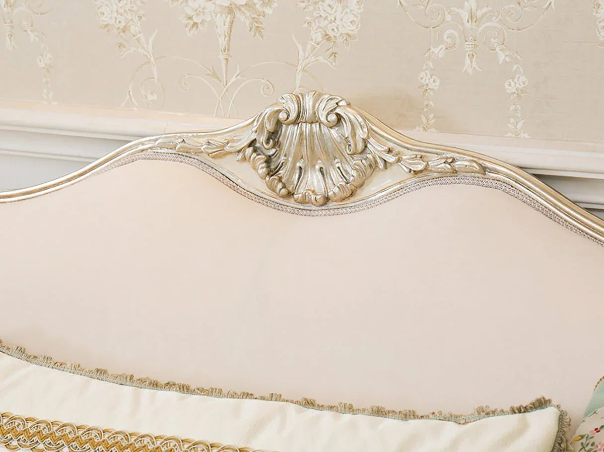 Carved crest and silver leaf detail of French sofa S-1169 on beech wood frame, paired with jacquard floral fabric accents.