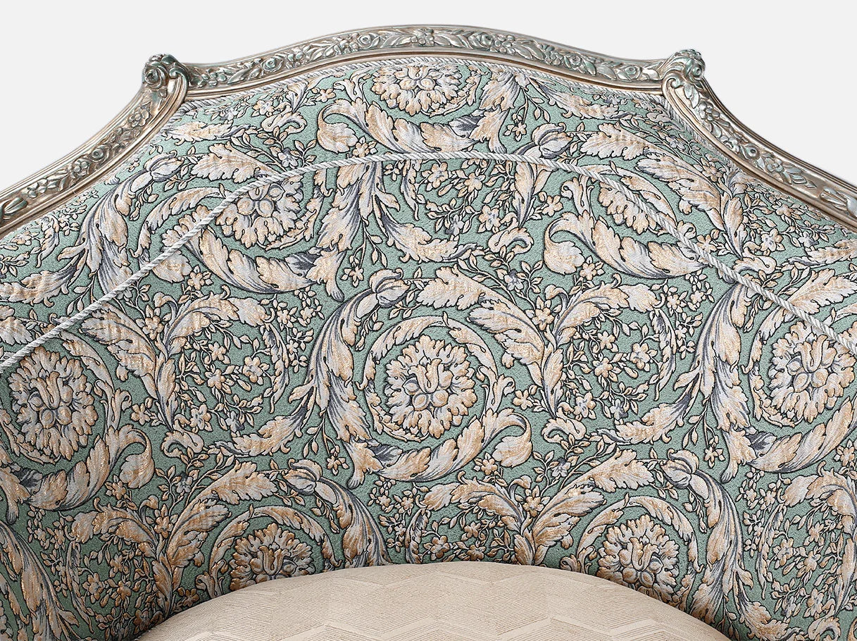 Carved crest detail of French armchair A-1192 with silver leaf highlights on beech wood frame.