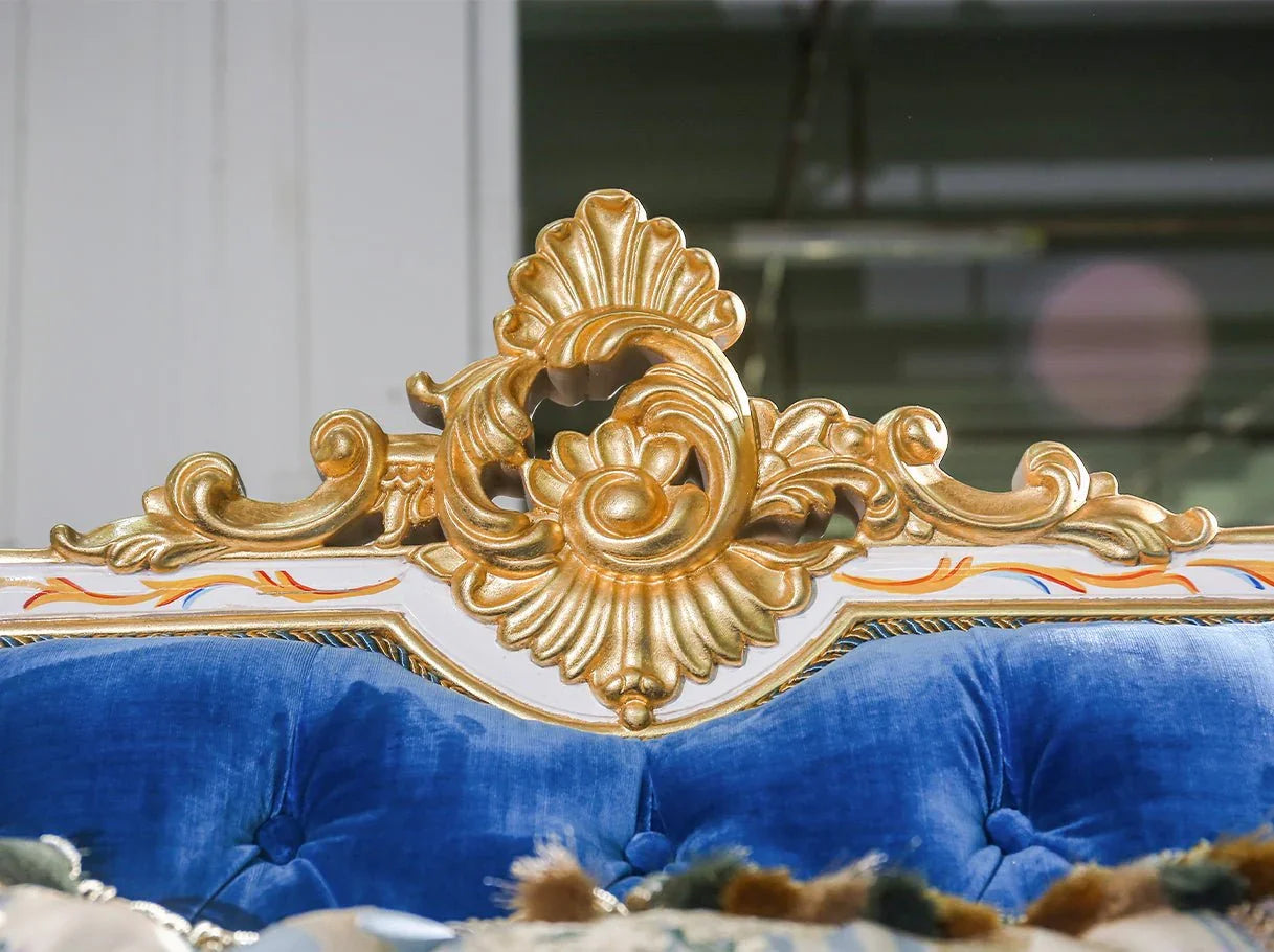 Close-up of armrest carving on French sofa S-1138 with blue velvet and gold leaf scroll details.