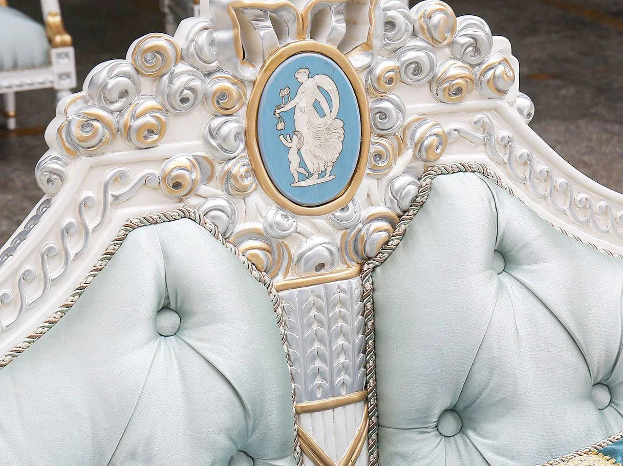 Close-up of French sofa S-1179 crest with ornate hand-carved scrollwork, cameo medallion, and shimmering gold leaf craftsmanship.