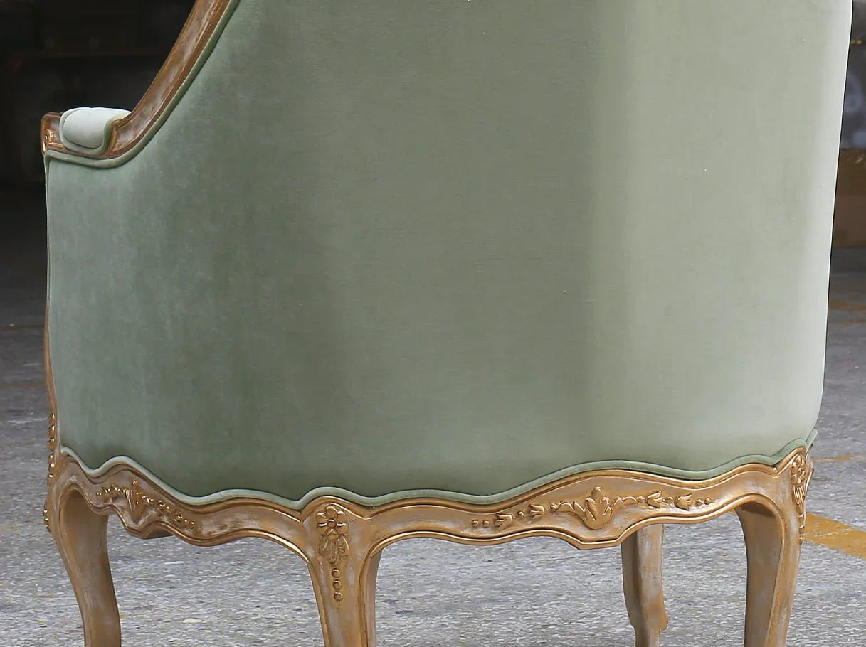 Rear side view of French armchair A-1181 highlighting smooth green velvet and carved golden base trim.