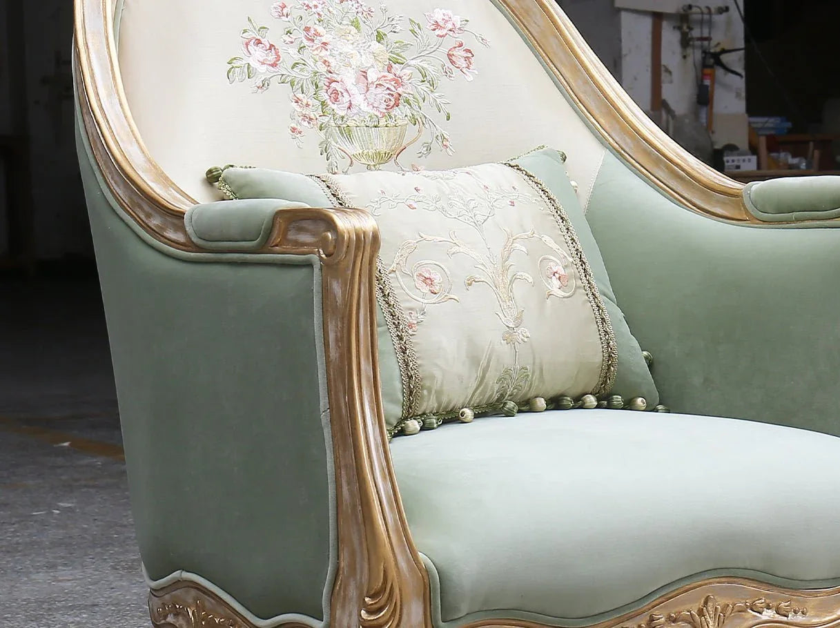 Close-up of French armchair A-1181 armrest detail with carved gilded edge and embroidered floral back.