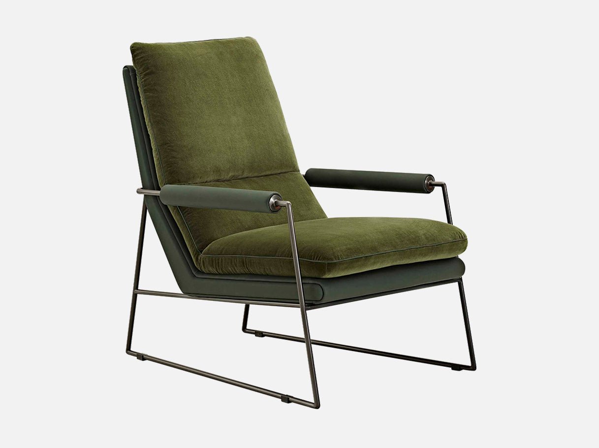 Side angle of Art Deco comfy bedroom armchair with slim metal frame and plush padding